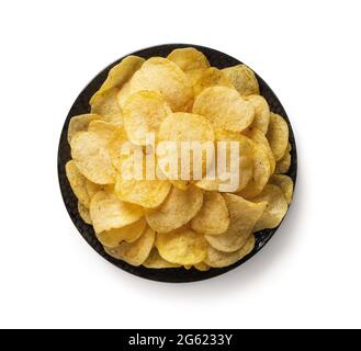 Patatine croccanti con aneto su una piastra di ceramica nera isolata su sfondo bianco. Gustoso spuntino di sottili fette di patate fritte. Alimentazione malsana. Foto Stock