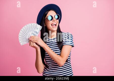 Ritratto fotografico di donna eccitata con bocca aperta che mostra i soldi fan isolato su sfondo color rosa pastello Foto Stock