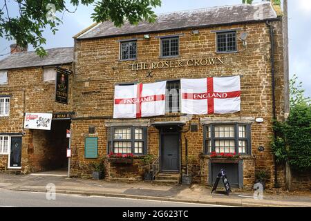 Due bandiere d'Inghilterra sono appese al pub Rose and Crown di Chipping Warden, Northamptonshire, a sostegno della squadra di calcio inglese. Foto Stock