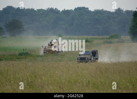 Esercito britannico Guerriero FV510 veicolo da combattimento fanteria e un esercito Land Rover Defender su manovre Wiltshire, Regno Unito Foto Stock