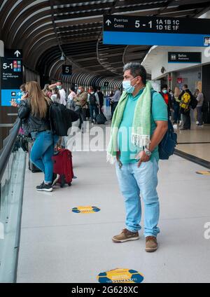 Medellin, Antioquia, Colombia - Maggio 17 2021: L'uomo latino con maschera guarda fuori dalla finestra vicino ad altre persone al terminale di Jose Maria Cordova A. Foto Stock