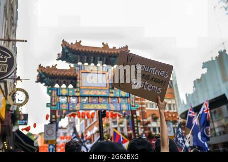 Un protester tiene un cartello durante la dimostrazione. Hongkongers ha tenuto manifestazioni in dieci diverse città del Regno Unito per protestare contro il primo anniversario della promulgazione della legge sulla sicurezza nazionale di Hong Kong e il centenario del Partito comunista cinese. A Londra, i partecipanti si sono riuniti fuori dall'ambasciata cinese e hanno marciato verso Chinatown, dove si è svolto l'evento principale. Le folle poi si trasferirono all'Hong Kong Economic and Trade Office e rimassero le zampate di fumo all'esterno come un segno simbolico di maledizione del governo di Hong Kong. (Foto di Hesther ng/SOPA Images/Sipa USA) Foto Stock