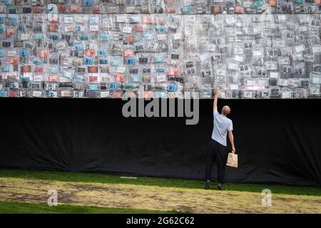 Manchester, Regno Unito. 01 luglio 2021. Un visitatore guarda un libro sul lato del Big ben sdraiato installazione che è stato creato dall'artista Marta Minujín. La replica di 42 metri del Big ben è coperta in 20,000 copie di libri che hanno plasmato la politica britannica e sono un invito gioioso per le persone a riimmaginare i loro simboli nazionali e unirsi intorno alla democrazia e all'uguaglianza. Il MIF è un festival organizzato da artisti che presenta nuove opere di varie arti dello spettacolo, arti visive e cultura popolare. (Foto di Andy Barton/SOPA Images/Sipa USA) Credit: Sipa USA/Alamy Live News Foto Stock