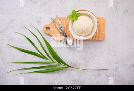 Gusti di gelato al cocco a metà della preparazione di cocco su sfondo di pietra bianca. Foto Stock