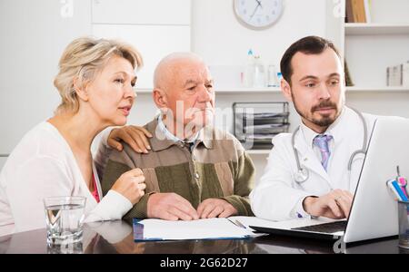 Il padre anziano con la figlia visita il medico Foto Stock