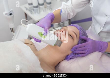 Salone di bellezza. Il cosmetologo effettua una procedura di peeling dell'acqua per il cliente. Vista laterale. Il concetto di cura professionale della pelle. Foto Stock