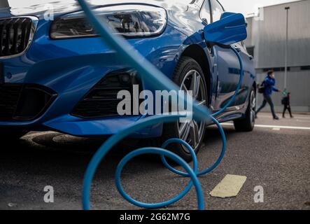 Lipsia, Germania. 07 maggio 2021. Un'auto elettrica si carica in un parcheggio di fronte allo stabilimento BMW di Lipsia. Credit: Hendrik Schmidt/dpa-Zentralbild/ZB/dpa/Alamy Live News Foto Stock