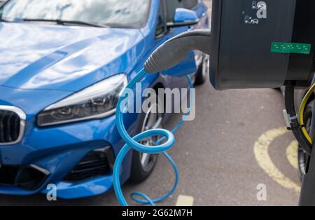 Lipsia, Germania. 07 maggio 2021. Un'auto elettrica si carica in un parcheggio di fronte allo stabilimento BMW di Lipsia. Credit: Hendrik Schmidt/dpa-Zentralbild/ZB/dpa/Alamy Live News Foto Stock