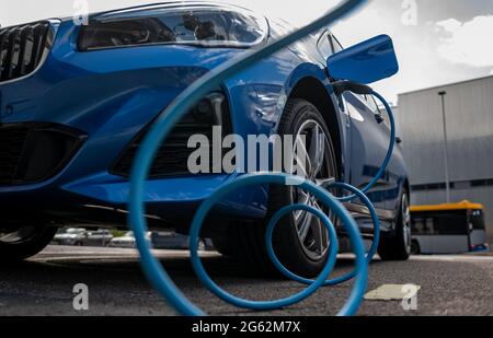 Lipsia, Germania. 07 maggio 2021. Un'auto elettrica si carica in un parcheggio di fronte allo stabilimento BMW di Lipsia. Credit: Hendrik Schmidt/dpa-Zentralbild/ZB/dpa/Alamy Live News Foto Stock