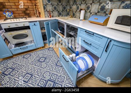 Moderna cucina classica di lusso e sala da pranzo, cassetti e porte aperte Foto Stock