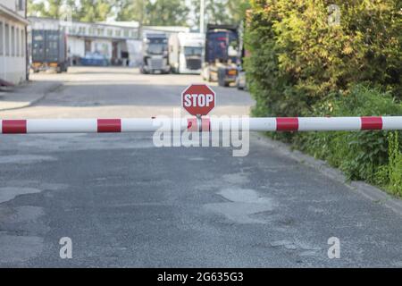 Barriera e segnale di stop sulla strada. Ingresso al cancello dell'organizzazione, al checkpoint e al cartello di stop Foto Stock