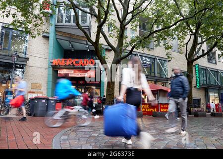 Amburgo, Germania. 01 luglio 2021. Passers-by a piedi attraverso la zona pedonale di Ottenser Hauptstraße dopo l'ingresso al centro commerciale Mercado. (Effetto di pulizia per esposizione a lungo termine) credito: Georg Wendt/dpa/Alamy Live News Foto Stock