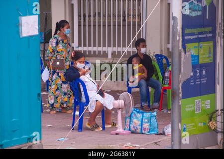 Phnom Penh, Cambogia. 2 luglio 2021. Per 4 mesi Phnom Penh sta combattendo un COVID - 19 di picco. In un luogo di prova di massa, una madre cambogiana incinta, Suo marito e il suo bambino hanno tutti provato positivo per il virus. I loro sacchetti sono imballati e stanno aspettando essere presi da un'ambulanza. Credit: Kraig Lieb Foto Stock