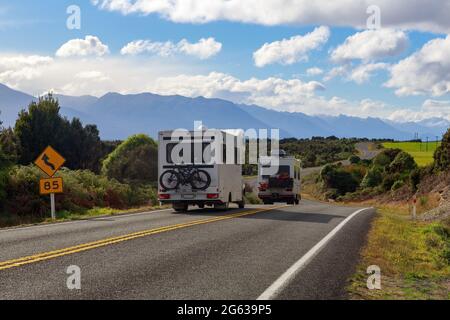 Veicoli ricreativi che guidano in Fiordland, Nuova Zelanda, attraverso un paesaggio panoramico Foto Stock