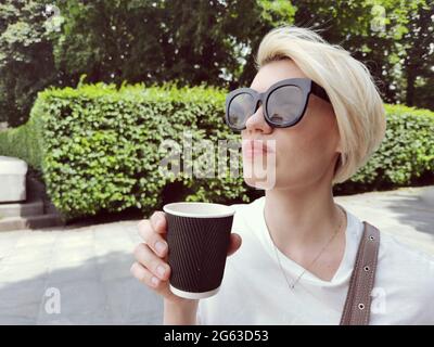 Bella donna adorabile con sorsi naturali di caffè al mattino presto all'alba o al tramonto da a tazza Foto Stock