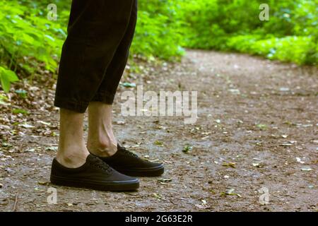 Gambe uomo in stivali neri con lacci sul bagnato Foto stock - Alamy