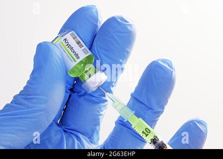 Primo piano della mano in guanti che tengono un flaconcino con kryptonite ed estraggono il liquido nella siringa per iniezione. Sanità, medicina, farmacia, vaccinazione Foto Stock