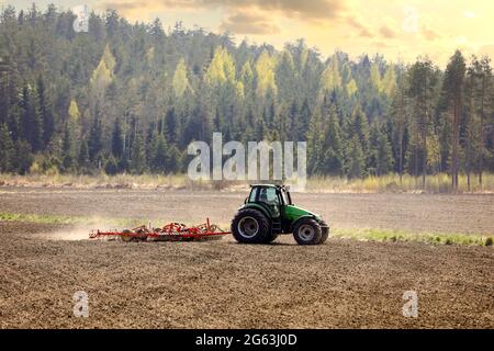 Campo coltivatore con trattore verde Deutz-Fahr Agrotron 135 e erstad NZ con erpice a denti aggressivo in primavera. Salo, Finlandia. 13 maggio 2021 Foto Stock