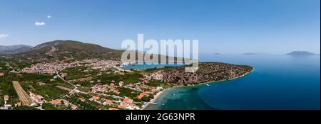 Grecia, antica baia di Epidauro ad Argolida. Vista panoramica aerea e drone del villaggio tradizionale e del Golfo Saronico, Peloponneso. Cielo blu, mare calmo, sole Foto Stock