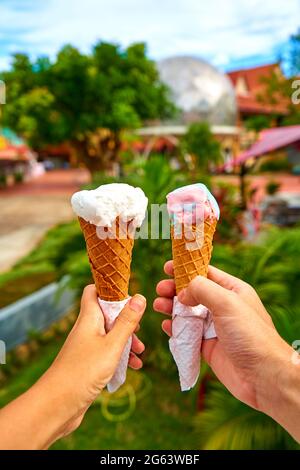 Una coppia scatta le immagini dei coni del gelato nelle loro mani. Foto Stock