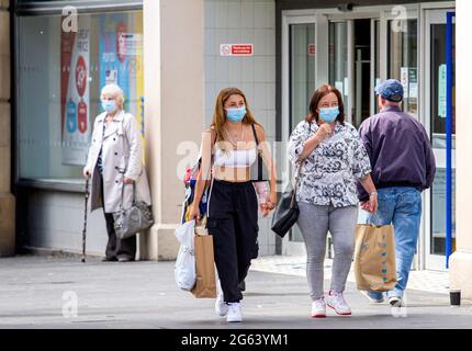 Dundee, Tayside, Scozia, Regno Unito. 2 luglio 2021. Regno Unito tempo: Una giornata fresca e ventosa con intervalli di sole in tutto il Nord-Est della Scozia con temperature che raggiungono i 17°C. I residenti locali sono ancora ben consapevoli delle linee guida di distanziamento sociale e l'uso di maschere facciali a Dundee. Una giovane donna alla moda che cammina con sua madre dopo una giornata di shopping al centro commerciale Overgate nella città di Dundee. Credit: Dundee Photographics/Alamy Live News Foto Stock