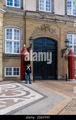 Copenhagen, Danimarca - 13 Giugno 2021: Guardia del palazzo in servizio di guardia fuori dal Palazzo Amalienborg nel centro di Copenhagen Foto Stock