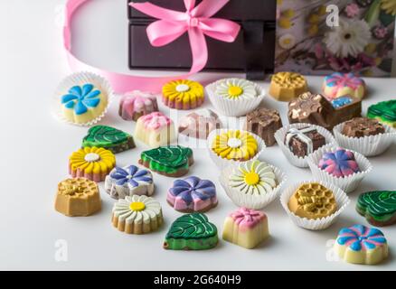 Selezione assortita di caramelle di cioccolato gourmet fatte a mano con deliziosi centri pralina, fondente e toffee isolato su sfondo bianco w Foto Stock