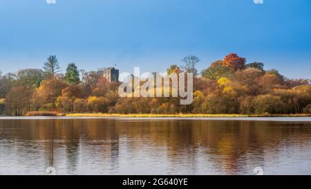 Colori autunnali al Mugdock Country Park sullo sfondo sono i resti del Castello di Mugdock risalente al XIII secolo Foto Stock