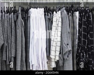 Abiti da collezione di base, scacchi e semplici, appendere su appendiabiti in negozio Foto Stock