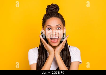 Foto di stupito scioccato afro americano giovane donna tenere mani faccia vendita isolato su sfondo giallo Foto Stock