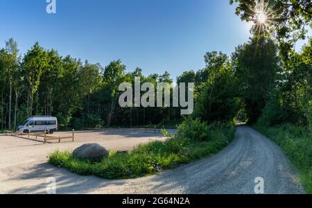 Skrille, Svezia - 17 giugno 2021: Camper grigio parcheggiato in un parcheggio sotterraneo nel mezzo della foresta con una stella solare Foto Stock