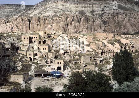 Il vecchio villaggio greco abbandonato in rovina di Cavusin in Turchia le case sono sotto la formazione vulcanica di roccia tipica della Cappadocia Foto Stock