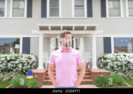 in vendita. bel realtor in attesa di visitatori. affittare nuova casa. proprietà. uomo sicuro fuori Foto Stock