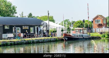 Caffetteria sul lato dell'acqua, noleggio biciclette, noleggio kayak e barca ormeggiata vicino al Patch Bridge sul Gloucester Sharpness Canal Foto Stock
