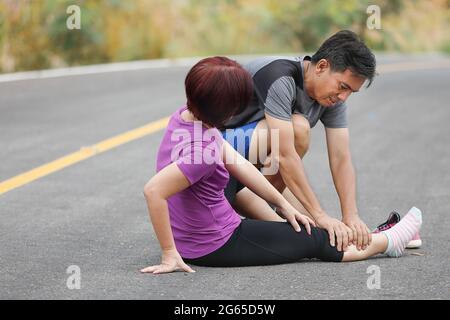 Femmina di mezza età con una cramp mentre jogging, massaggio vitello Foto Stock