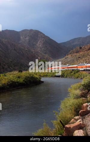 Un treno che corre lungo un fiume vicino alla Great Gorge vicino a Colorado Springs Foto Stock