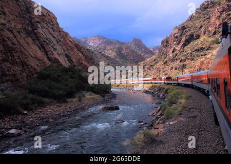 Un treno che corre lungo un fiume vicino alla Great Gorge vicino a Colorado Springs Foto Stock