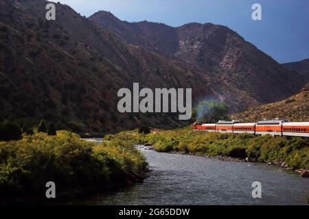 Un treno che corre lungo un fiume vicino alla Great Gorge vicino a Colorado Springs Foto Stock