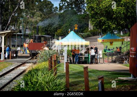 I turisti che cavalcano sulla replica di Mary Ann locomotiva a vapore a Maryborough Qld. Australia Foto Stock