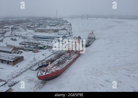 Arkhangelsk, Russia - 26 dicembre 2020: Paesaggio invernale del fiume e ormeggiate navi a riva. Foto Stock