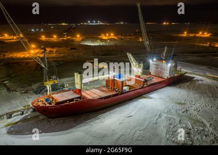 Sabetta, regione di Tyumen, Russia - 02 dicembre 2020: La nave da carico a secco è impegnata in operazioni di carico presso l'ormeggio. La nave è congelata nel ghiaccio. Foto Stock