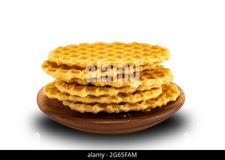 Impilate i dolci waffle croccanti fatti in casa in un piatto di legno su sfondo bianco con un percorso di ritaglio. Foto Stock