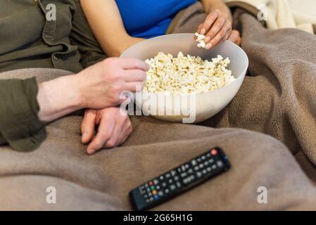 Dettaglio della coppa popcorn. Uomo e donna irriconoscibili. Foto Stock