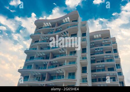 Uno sguardo ravvicinato di un edificio di nuova costruzione con nuvole e cielo blu sullo sfondo Foto Stock