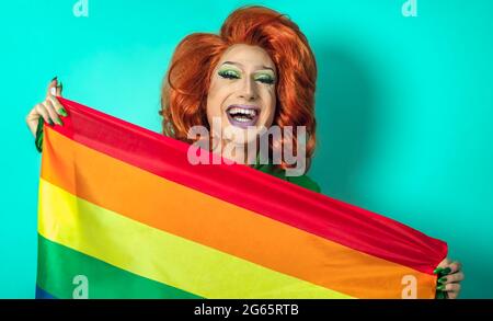 Happy Drag Queen che celebra l'orgoglio gay con bandiera arcobaleno simbolo della comunità LGBTQ Foto Stock