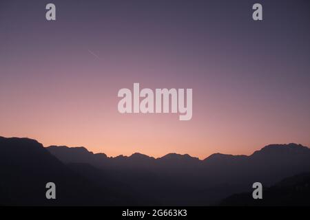 Una vista del tramonto con una montagna sullo sfondo Foto Stock