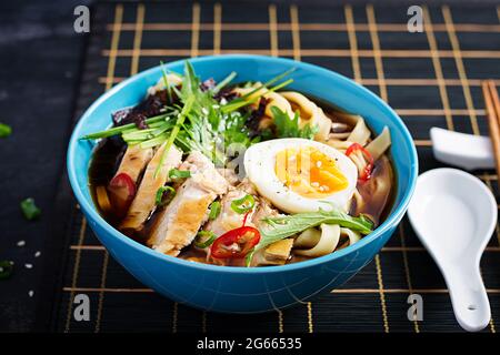 Zuppa di miso. Zuppa giapponese di ramen con pollo, uovo, nori e nippposinica su fondo scuro. Foto Stock