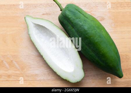 Vista ad alto angolo di tutta la papaia verde e un'altra tagliata a metà su tagliere, spazio di copia. Foto Stock
