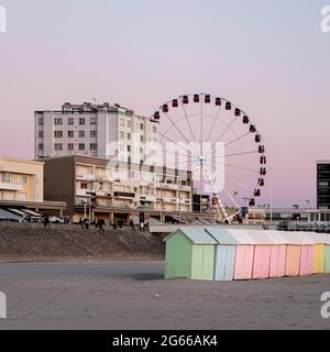 Cabine sulla spiaggia dai colori pastello e ruota gigante sulla spiaggia Di Berck in Francia Foto Stock