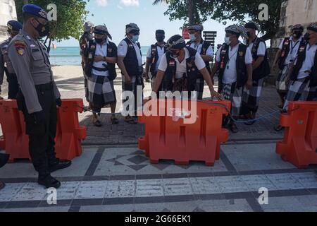 Denpasar, Indonesia. 3 luglio 2021. I membri del personale di sicurezza tradizionale balinese, il pecalang, hanno creato dei blocchi durante una chiusura stradale come parte delle misure di restrizione locali COVID-19 presso il sito turistico della spiaggia di Sanur a Denpasar, Bali, Indonesia, il 3 luglio 2021. Indonesia il Sabato ha registrato 27,913 nuovi casi di COVID-19 nelle ultime 24 ore, un altro record del picco quotidiano, portando il totale a 2,256,851, il Ministero della Salute ha detto. Credit: Bisinglasi/Xinhua/Alamy Live News Foto Stock